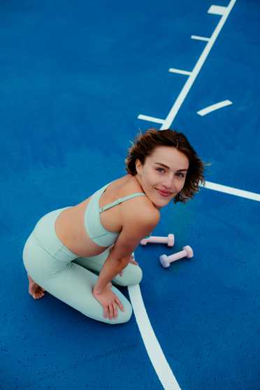 Woman in workout clothes on a blue exercise surface